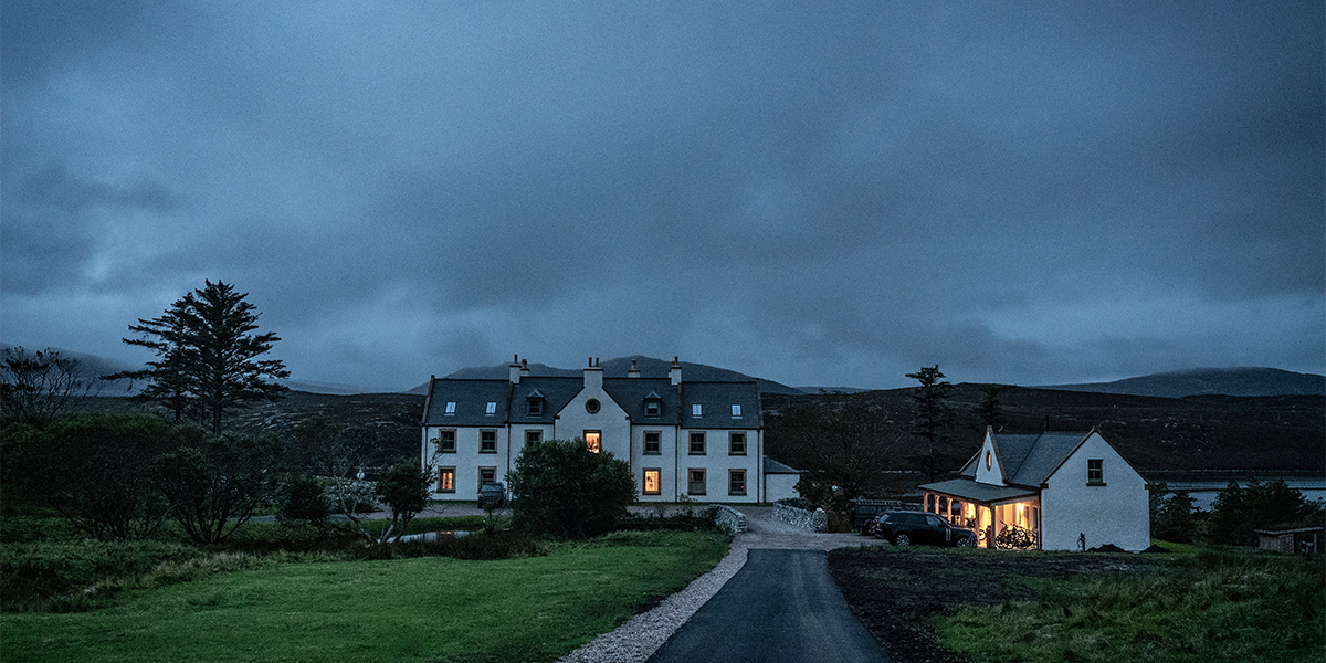 SCALISCRO lodge illuminated at dusk within the remote Hebridean landscape